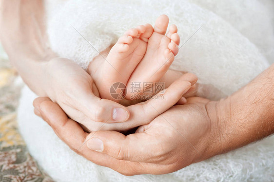 父母手中的婴儿脚父母的小新生儿的脚形手特写父母和他们的孩子幸图片