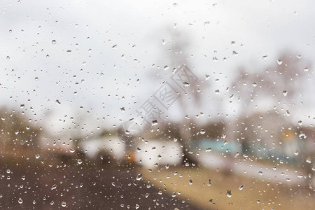 清澈的玻璃上的雨滴远离遥远的模糊图片