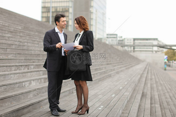 层和客户站在灰色的大楼梯上女人手里拿着关于法庭陈述的文件男人诉说完结的诉讼很好图片