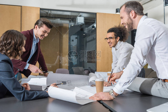 一群微笑着的建筑设计师在办公大楼计图片