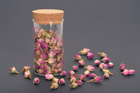 灰色玻璃罐中美丽的干粉红玫瑰花蕾图片