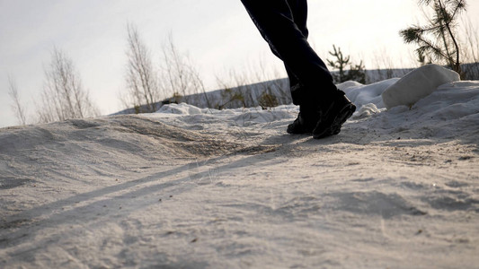 穿着冬鞋在雪地上行走的男腿的特写镜头冬天穿着雪鞋和钉在雪地上行走的景色穿靴子的男士腿关闭了白图片