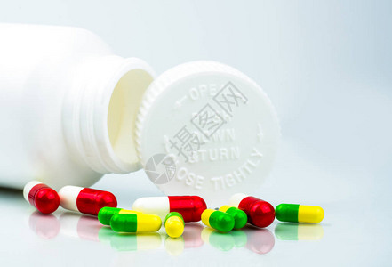 白色背景上的彩色药丸和带有空白和复制空间的塑料瓶儿童安全包装儿童抗药丸容器向下推并转动上限全球图片