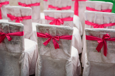 用白色织物和粉红丝带装饰的婚礼椅子图片