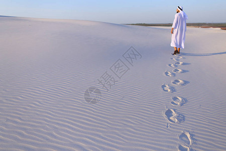 充满自信的阿拉伯旅游者徒步走在大片白沙漠中图片