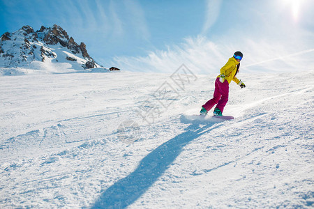 白天在雪坡上滑雪的运动女子照片图片