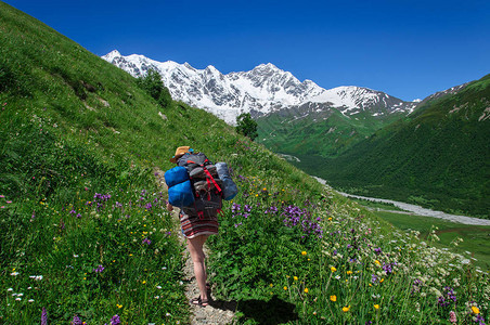 一个背包大起的游客在一条山路上登山路背景图片