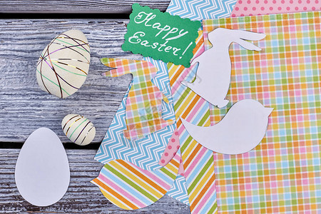 绿色复活节贺卡手工纸制品和旧木桌上的聚苯乙烯泡沫塑料装饰背景图片