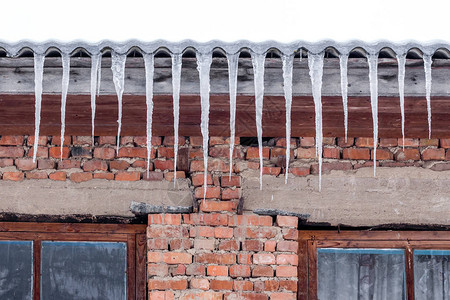 冰柱从老房子的屋顶上挂起冬图片