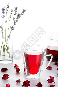 桌子上放着装有木槿茶的双层玻璃杯背景上有一个玻璃茶图片