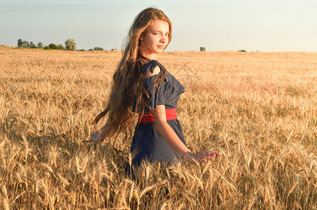 女孩站在阳光下的田地上图片