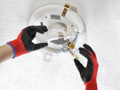 电工技术人员在住宅电气系统中用低功耗LED灯泡替图片
