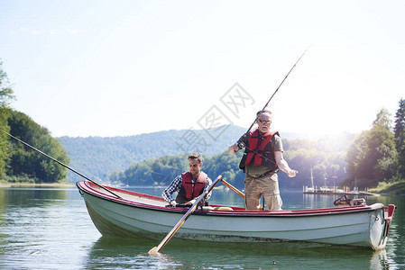 老人带着儿子在湖里钓鱼图片
