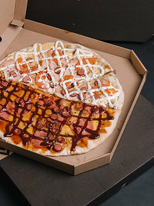 火腿香肠辣椒尼马扎里拉番茄烧烤酱和蛋黄酱两种不同种类的比萨饼图片