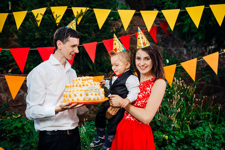 主题儿童的生日派对食物和糖果一个年轻的家庭庆祝儿子一周岁爸拿着一个大蛋糕图片