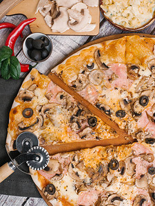 用番茄酱马苏里拉奶酪火腿橄榄和蘑菇放在木制比萨盘上图片