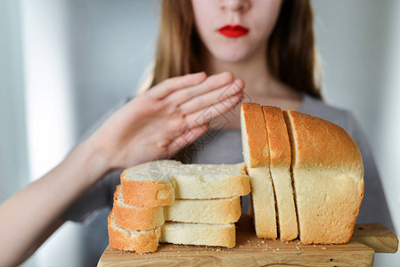 麸质不耐受和饮食概念年轻女孩拒绝吃白面包浅景深选择图片
