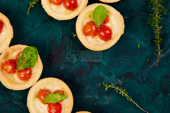 有樱桃西红柿的迷你松饼绿色背景的辣椒奶图片