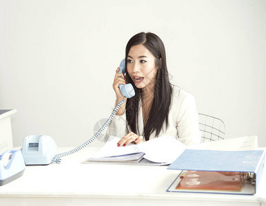 商业女商人在办公桌通过电话对成本图片