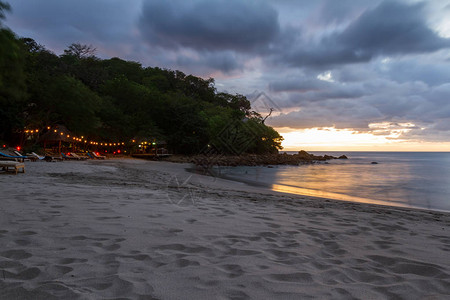 尼加拉瓜海滩上美丽的日落以缓慢的百叶速来模糊海浪运动并照亮黑暗图片