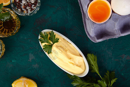 自制酱蛋黄酱和配料鸡蛋油柠檬芥末在绿色背图片