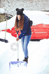 一名年轻女子清洁雪的冬季肖像美丽快乐模特女孩笑着用铲子玩得开心户外美图片