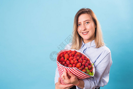 草莓花束在一个女孩的手中特写背景图片