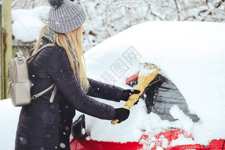 美丽金发女模特儿欢笑并愉快地扫雪图片