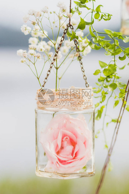 婚纱装饰穿着透明的吊瓶白花和粉红色花图片