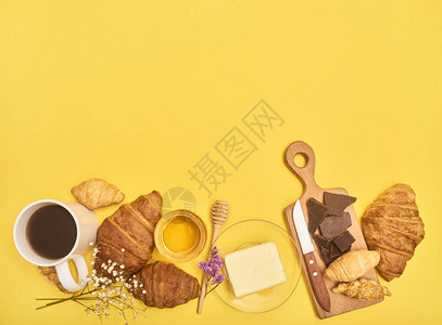 黑咖啡奶油巧克力小刀蜂蜜和黄色背景的白色小花朵图片