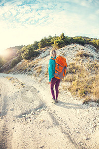 一个背着包的女孩沿着山路走着一个女人走在石板路上一个金发女郎图片