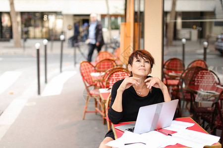 老年女编剧坐在户外咖啡馆里图片素材