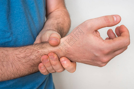 手腕疼痛的男人握着他疼痛的手图片