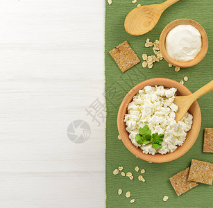 酸奶干酪在一个木碗和勺子在一张白色的木桌上健康的乳制图片