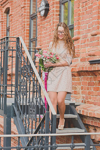 一个女孩拿着一大束郁金香和一件米色蕾丝连衣裙图片