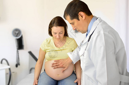 医生在他的怀孕病人中感觉到胎儿的身势图片