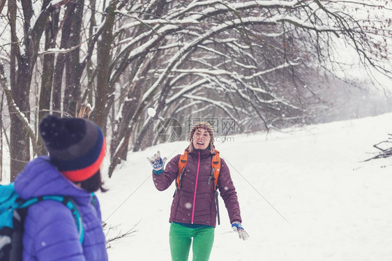 朋友们玩雪球妇女们在冬天的森林里散步女孩们在冬季比赛中在雪地公园度图片