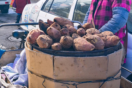 街上卖马铃薯的卖家在炉灶箱上出售图片
