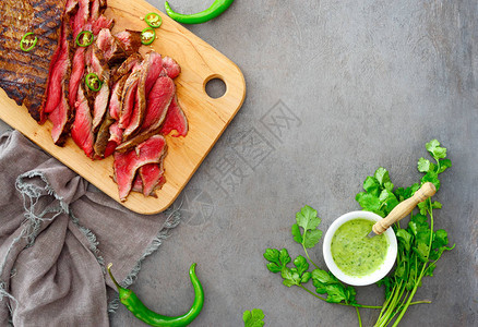 背景和侧面牛排准备吃切的菜在木板上供餐配有辣椒酱高图片