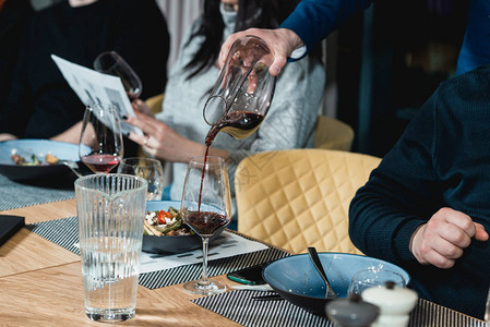 在品酒会上供应餐桌品酒师将红酒从醒酒器高清图片桌上摇酒器里的鸡尾