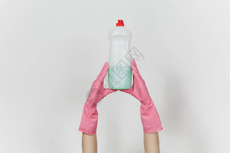 戴粉色手套的女手的特写是白色瓶子图片