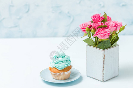 装饰着纸杯蛋糕和粉红玫瑰花束图片