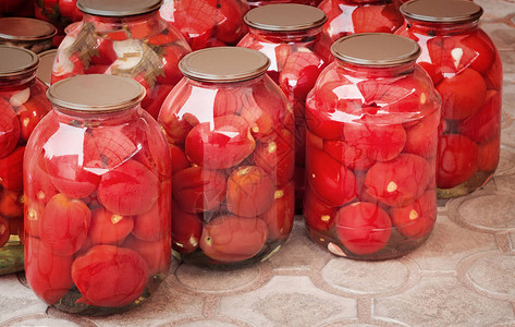 装有红熟罐头番茄的玻璃瓶由图片