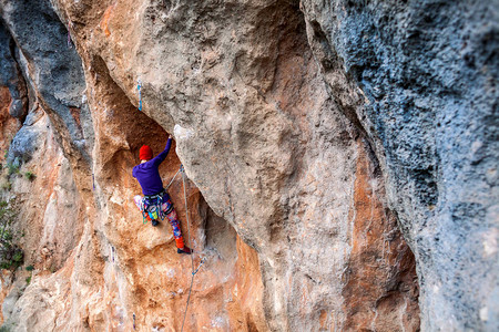 太阳能屋顶岩石上的攀岩者这个女孩正在上升自然运动积极的生活方式和户外健身一个极端的爱好背景