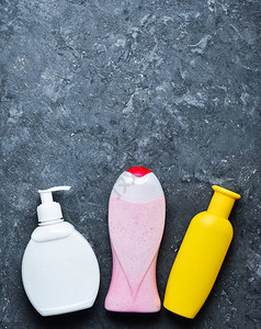 用于在黑色混凝土表面上淋浴的瓶装产品洗发水肥皂沐浴露复制空间图片