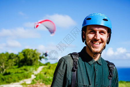滑翔伞的快乐脸近在咫尺在巴厘岛的海上滑翔伞蔚蓝的天空与蔚蓝的海洋闪烁着光芒带复制空图片