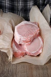 一堆新鲜切碎的生猪肉牛排在骨头上包装纸图片