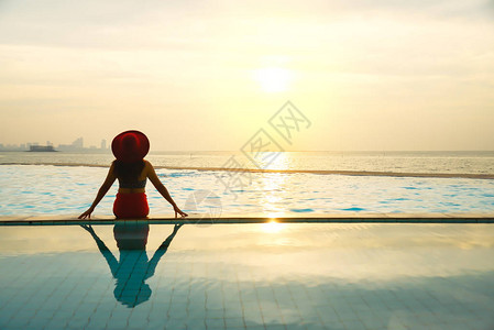 穿着大帽子的年轻女人在游泳池放图片