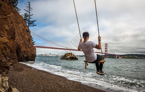 金门桥和旧金山背景的年轻人在秋天挥图片