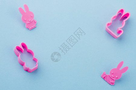 兔形粉红色硅胶模具用于在蓝色背景和复制空间上烘烤饼图片